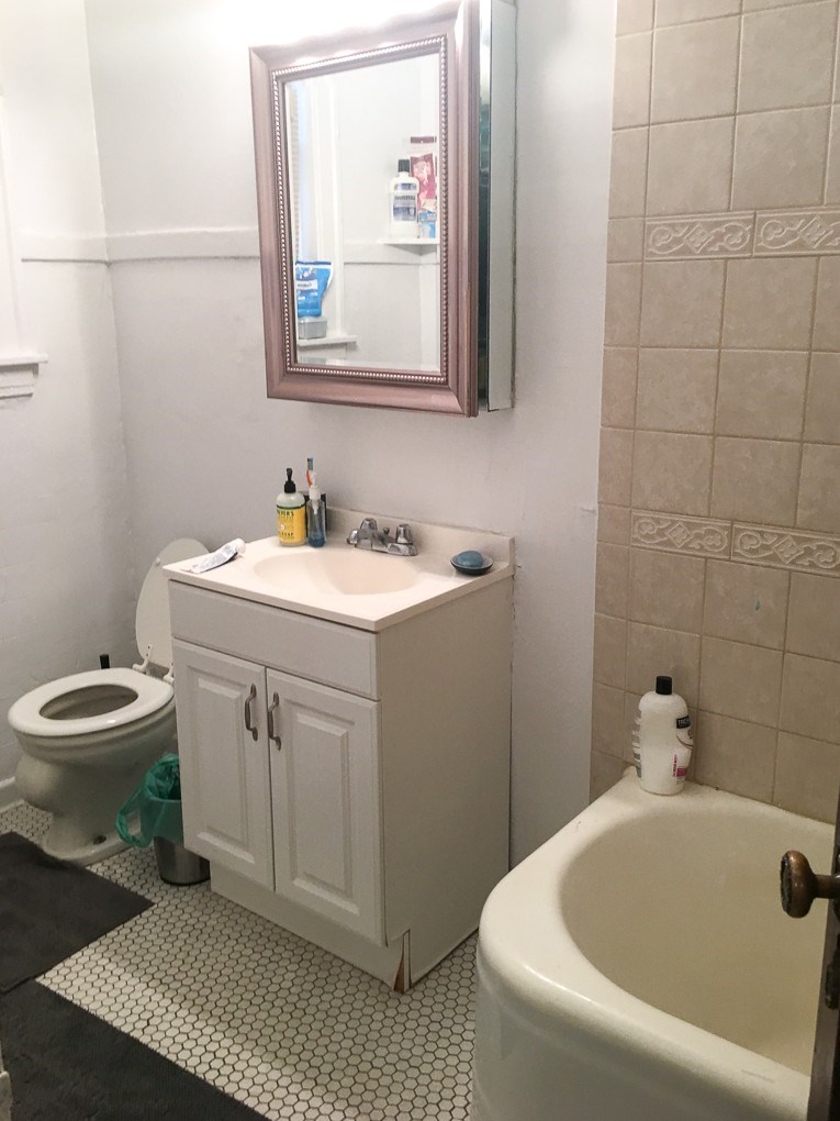 A white bathroom with a toilet, sink, and bathtub.