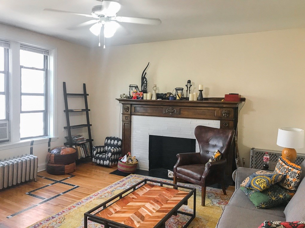 A living room with a fireplace and a brown leather chair.
