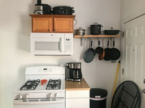 A kitchen with a white stove, a microwave, and a coffee maker.