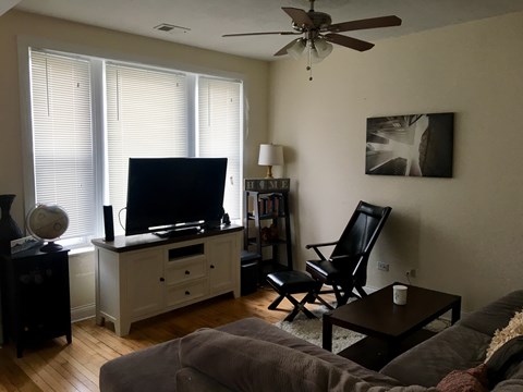 A living room with a grey couch and a black chair.