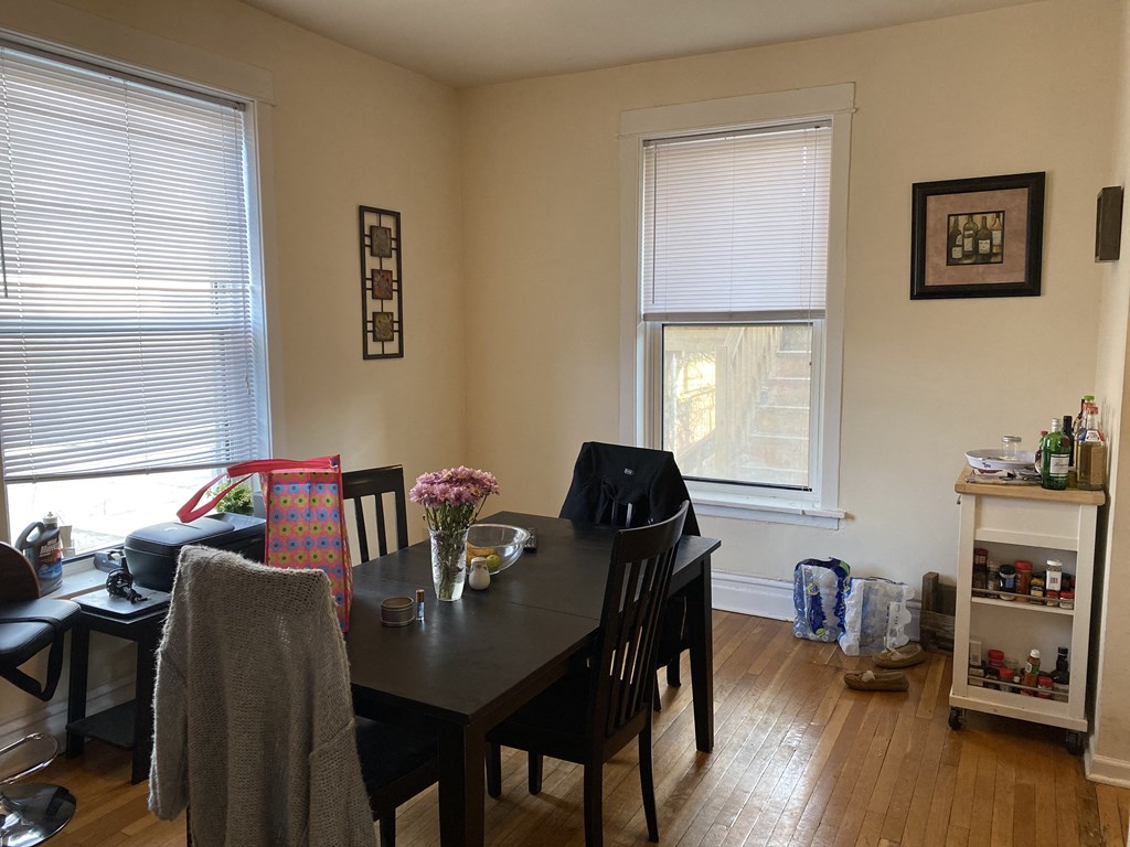 a dining room with a table and chairs and two windows