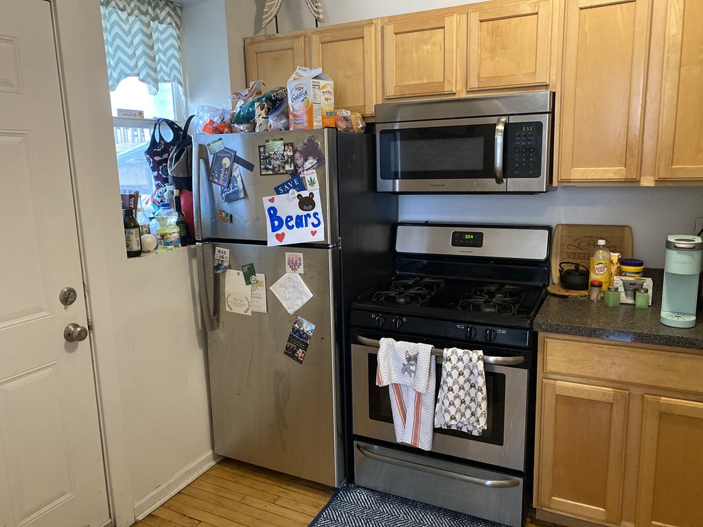 a kitchen with a stove refrigerator and microwave