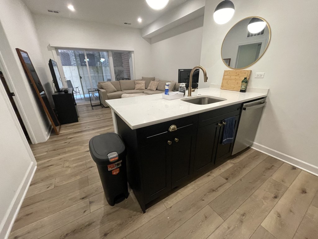 a kitchen with a sink and a counter top and a living room with a couch