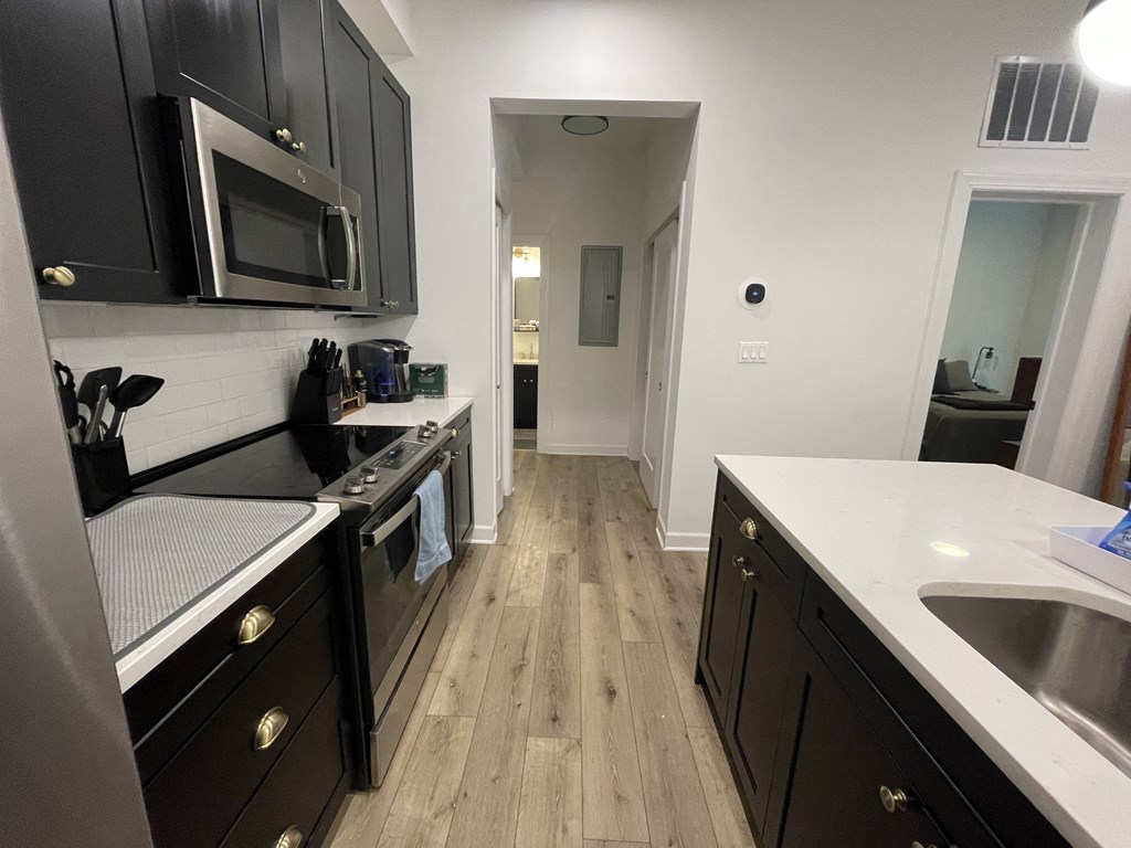 a kitchen with black cabinets and a stove and a microwave