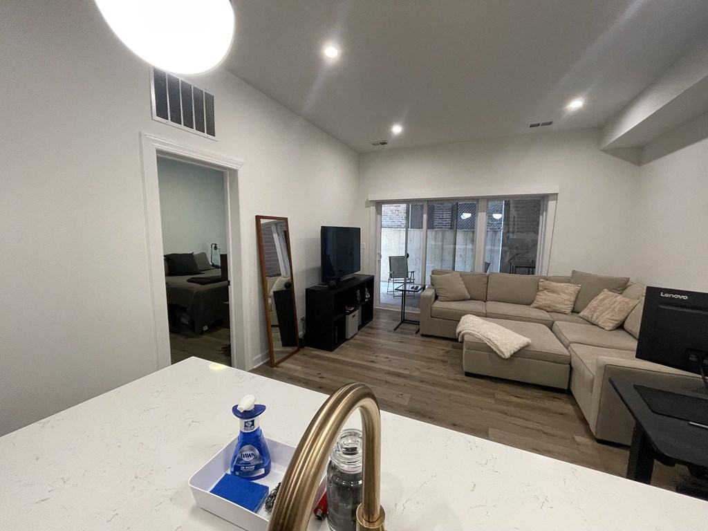 a living room and dining room with couches and a tv