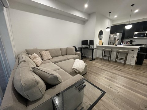 a living room with a large couch and a kitchen