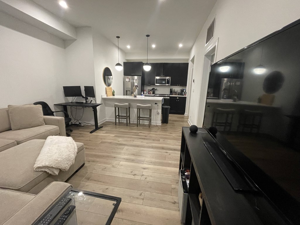 a black and white living room and kitchen with a piano