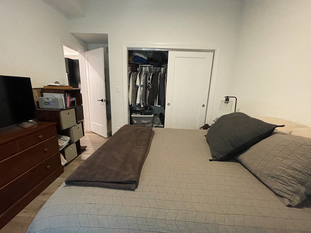 a bedroom with a bed and a closet with a dresser