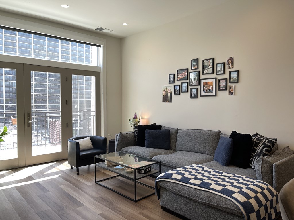 a living room with a grey couch and a black and white checkered ottoman