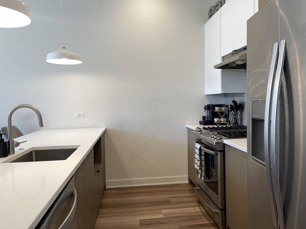 a kitchen with white countertops and stainless steel appliances