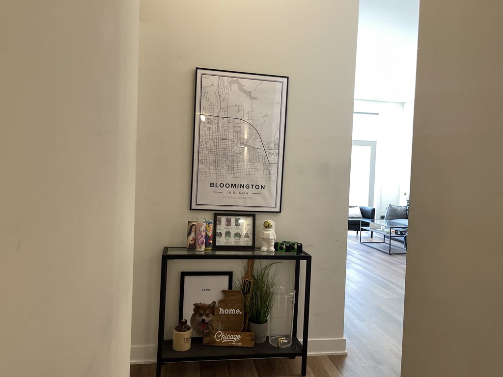 a hallway with a console table and a framed map of boston on the wall