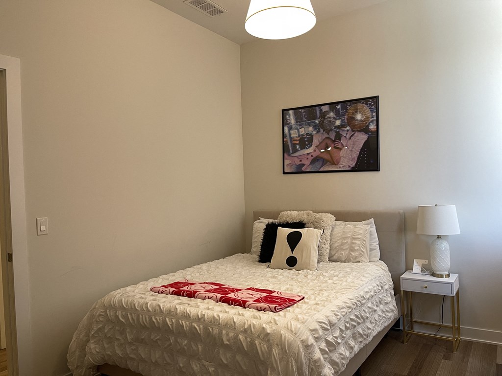 a bedroom with a bed and a painting on the wall