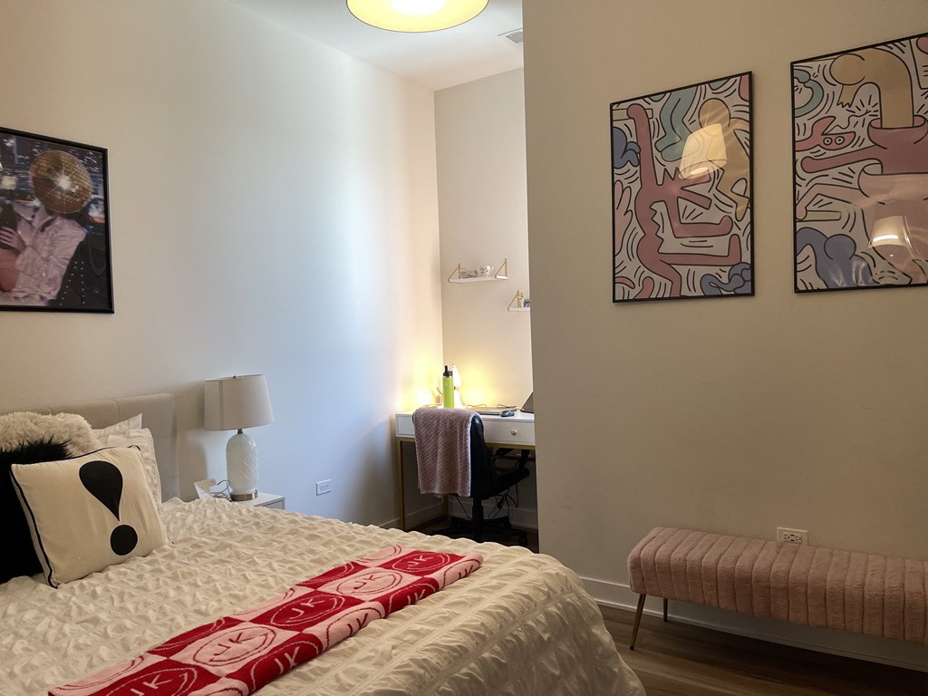 a bedroom with a bed and two paintings on the wall