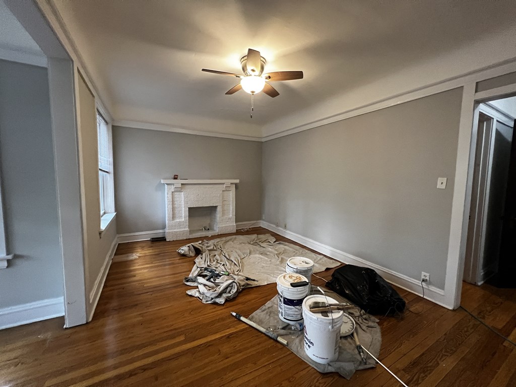 a living room with a fire place and a ceiling fan