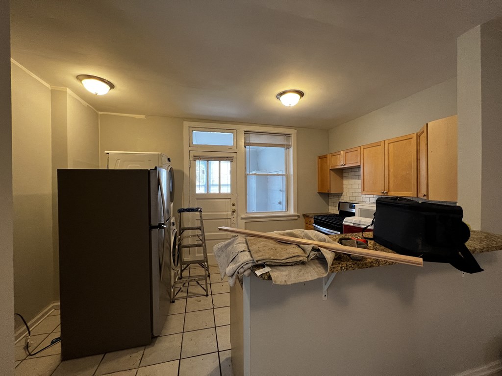 a kitchen with a refrigerator freezer and a stove top oven