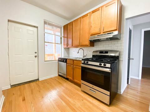 A kitchen with wooden cabinets and a black stove top oven.