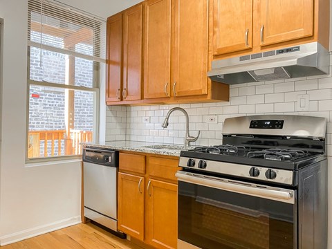 A kitchen with wooden cabinets and a stove top oven.