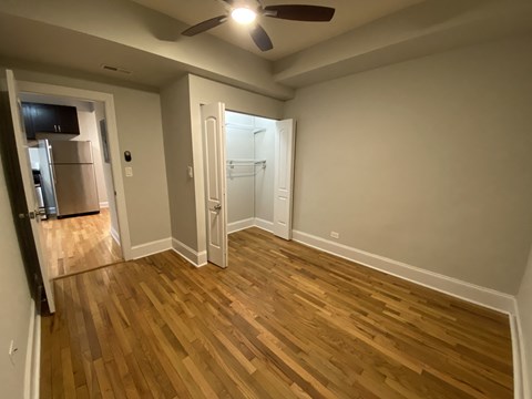 A room with wooden flooring and a ceiling fan.