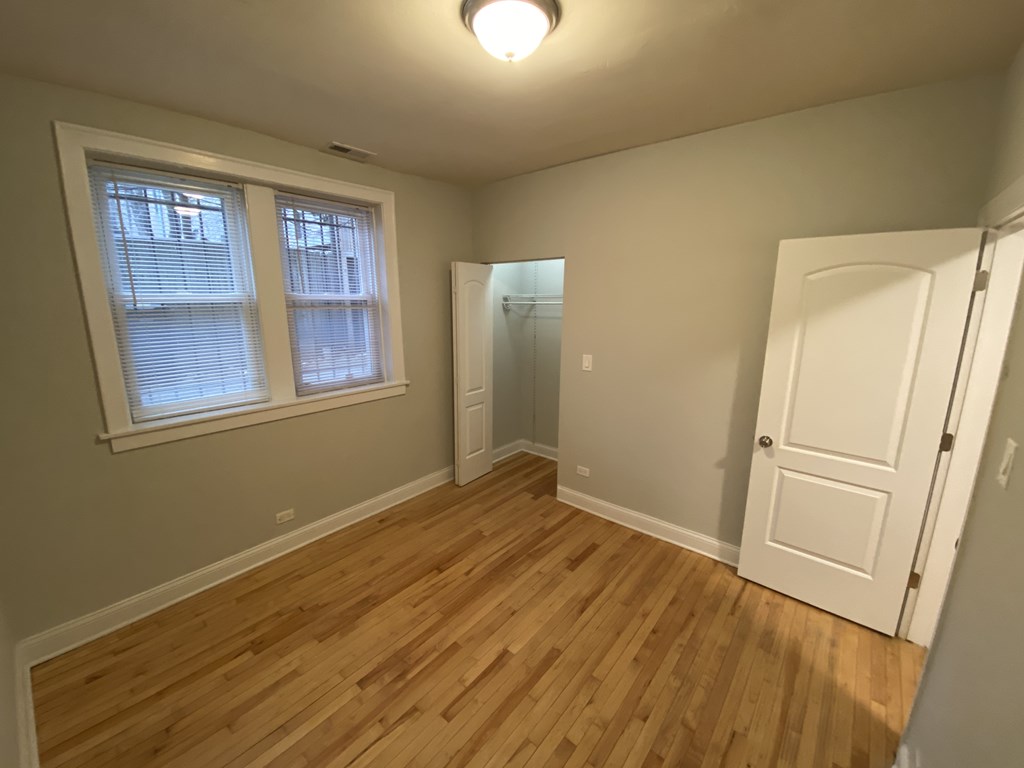 A room with wooden flooring and a white door.