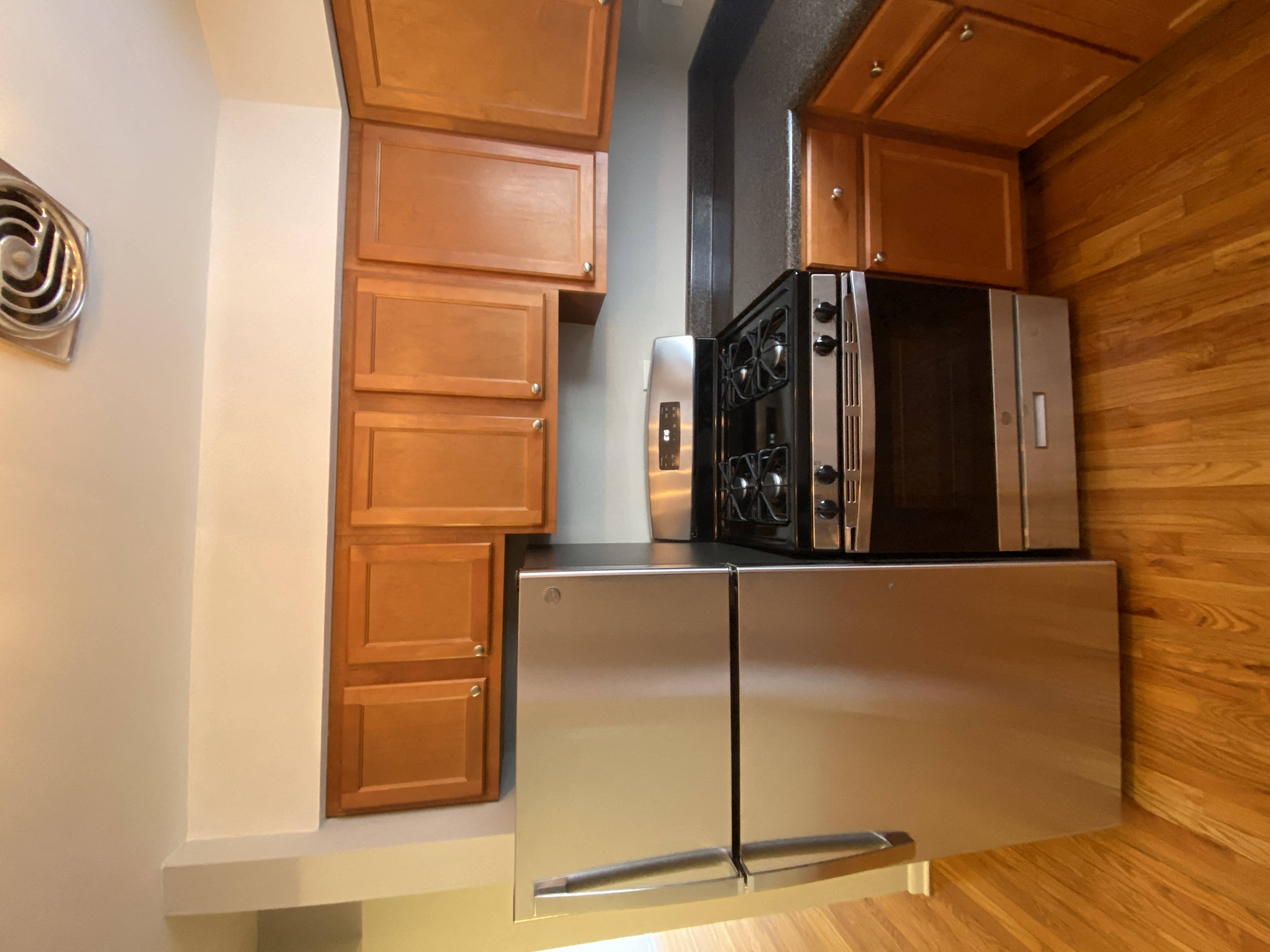 a kitchen with a stainless steel refrigerator and a microwave