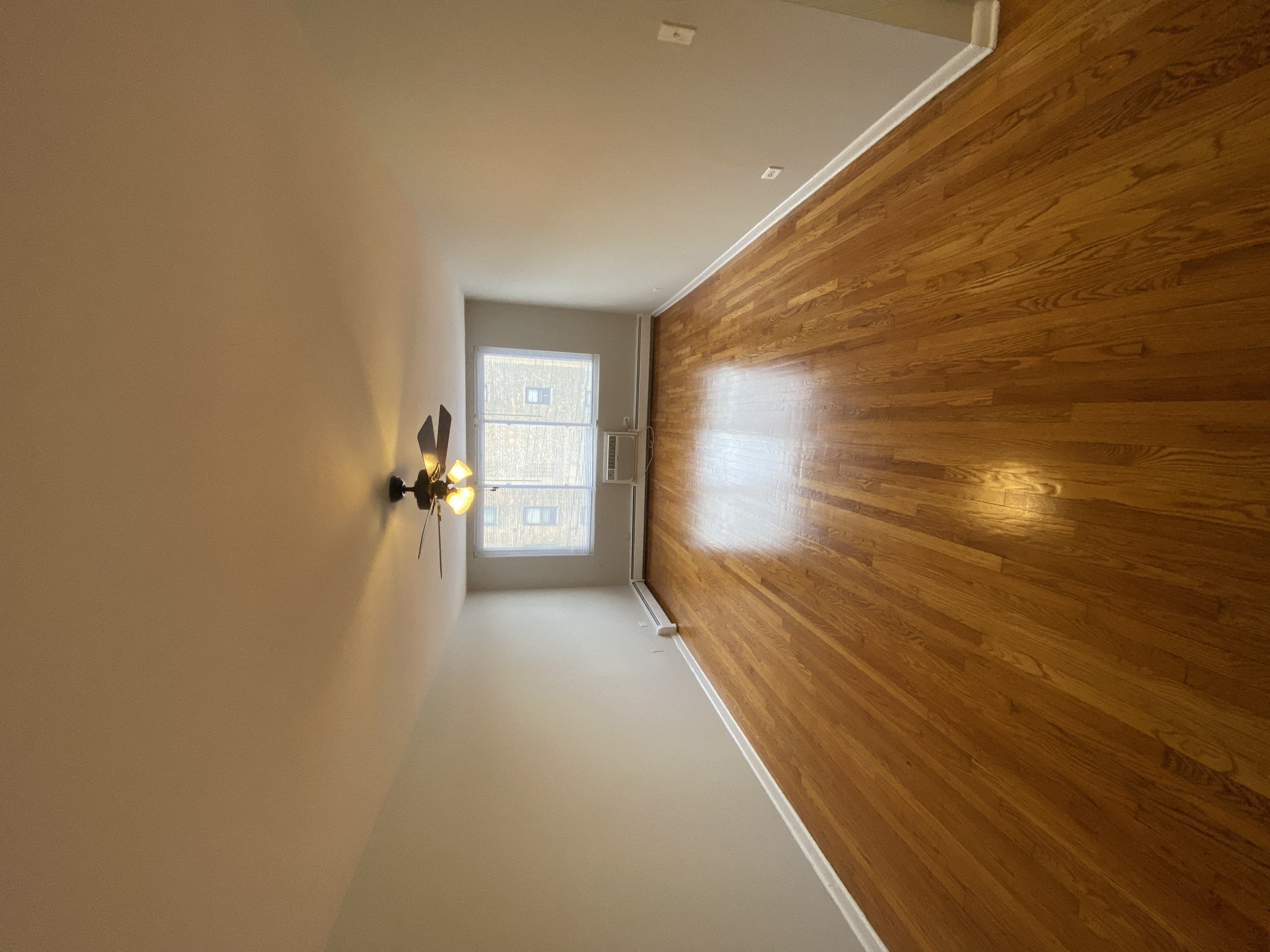 a hallway with wood paneling on the wall and a window