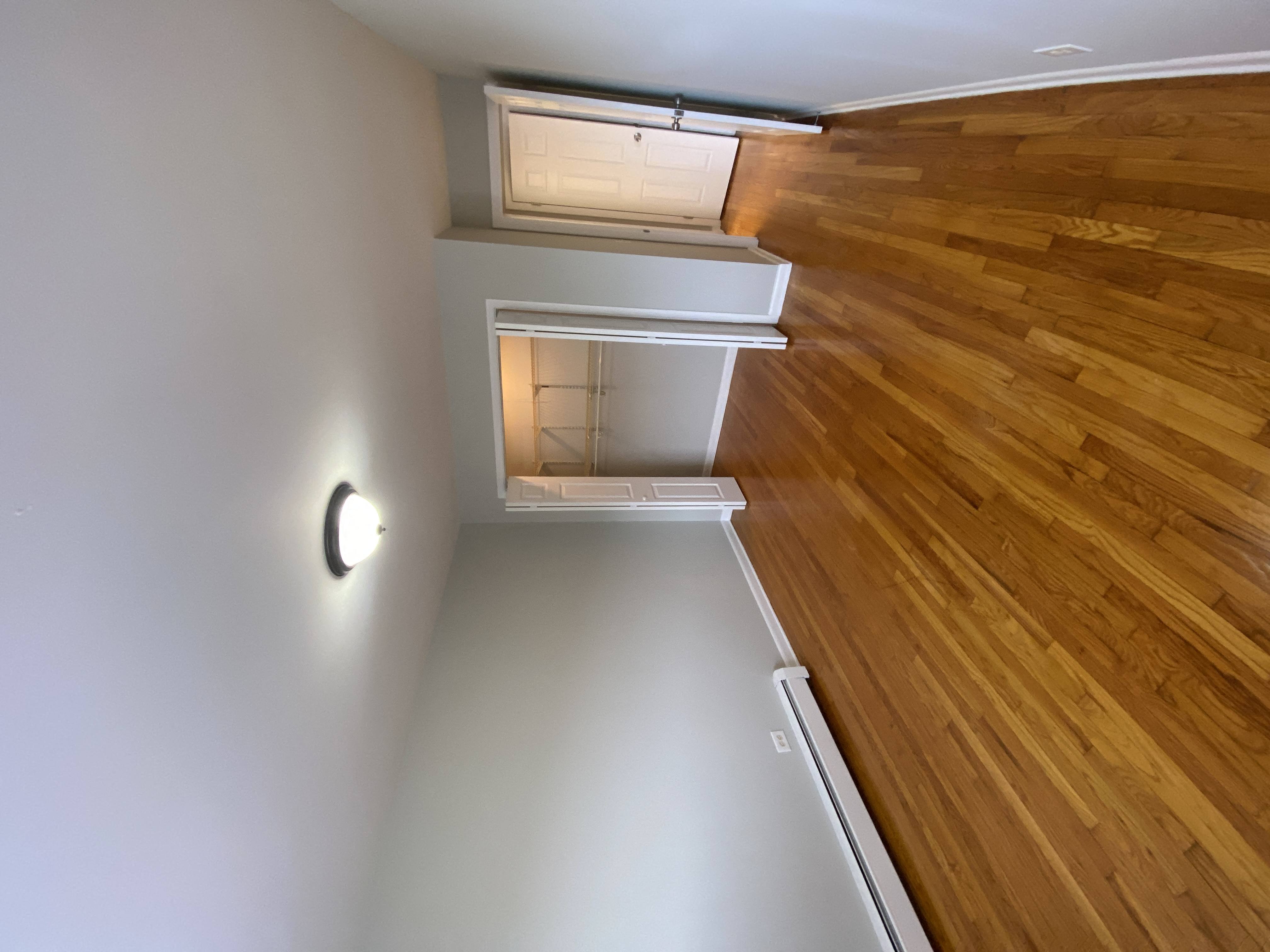 a view down the hallway of a house with wood floors and white walls
