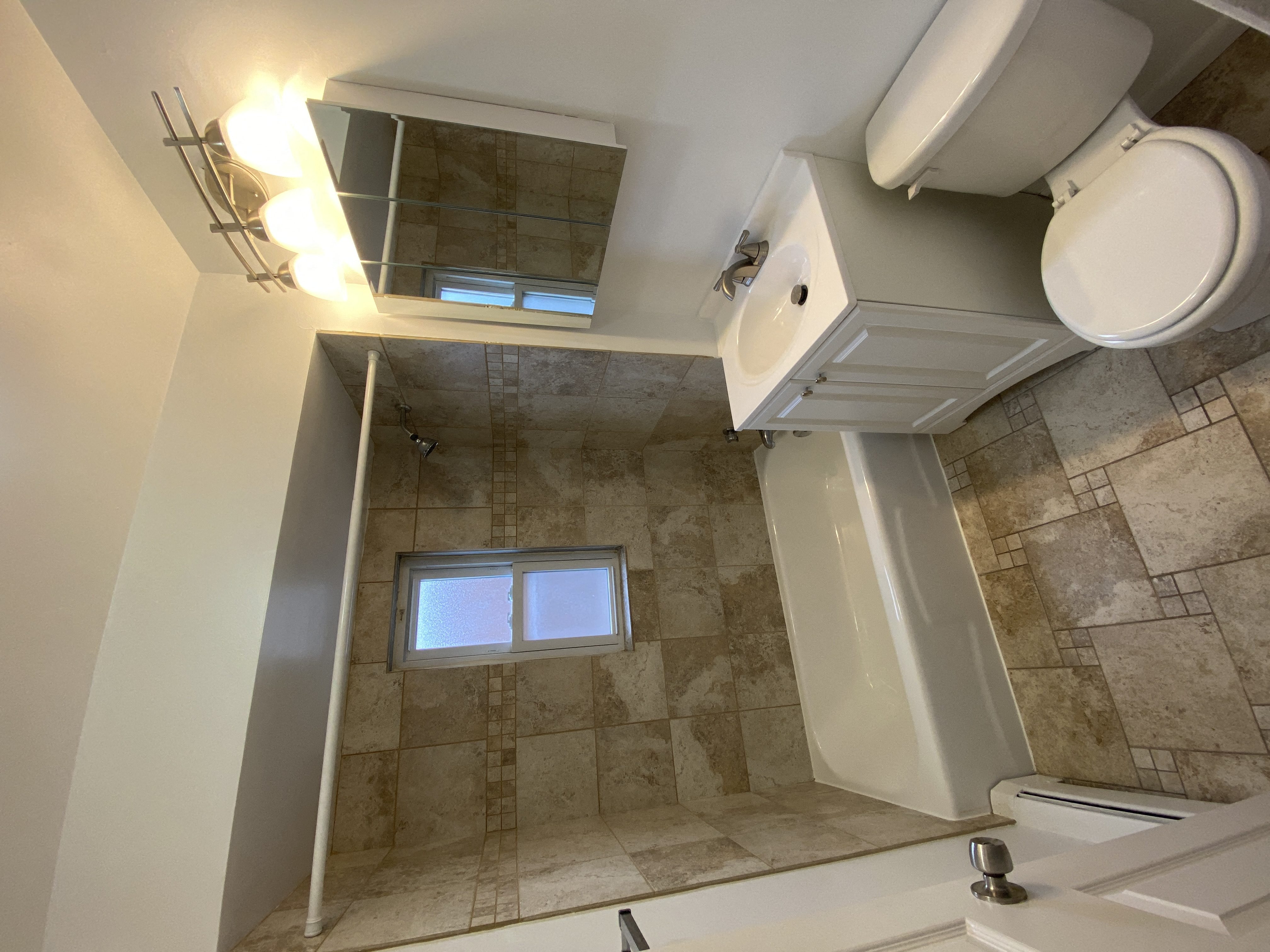 a bathroom with a toilet and a shower and a sink