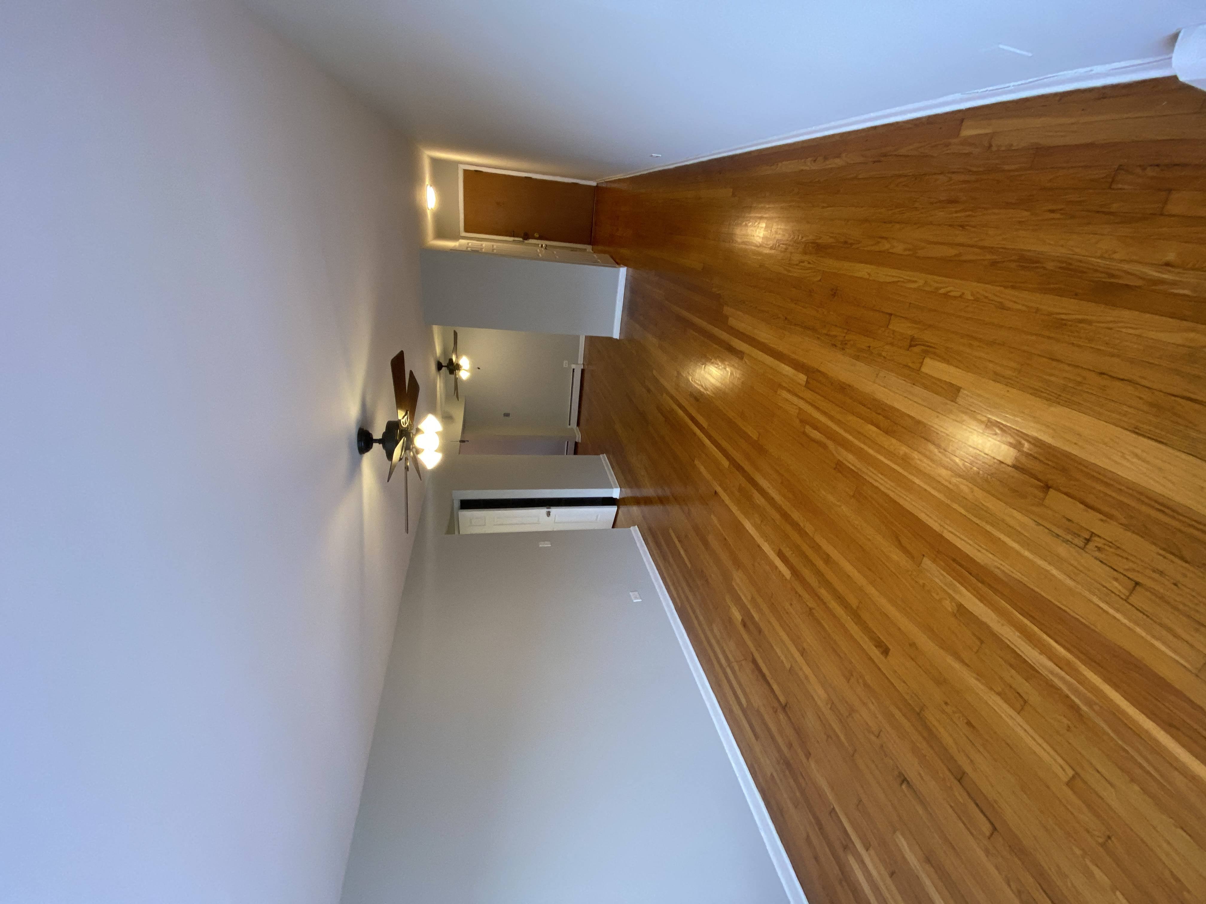 a view down a hallway with wood flooring and white walls