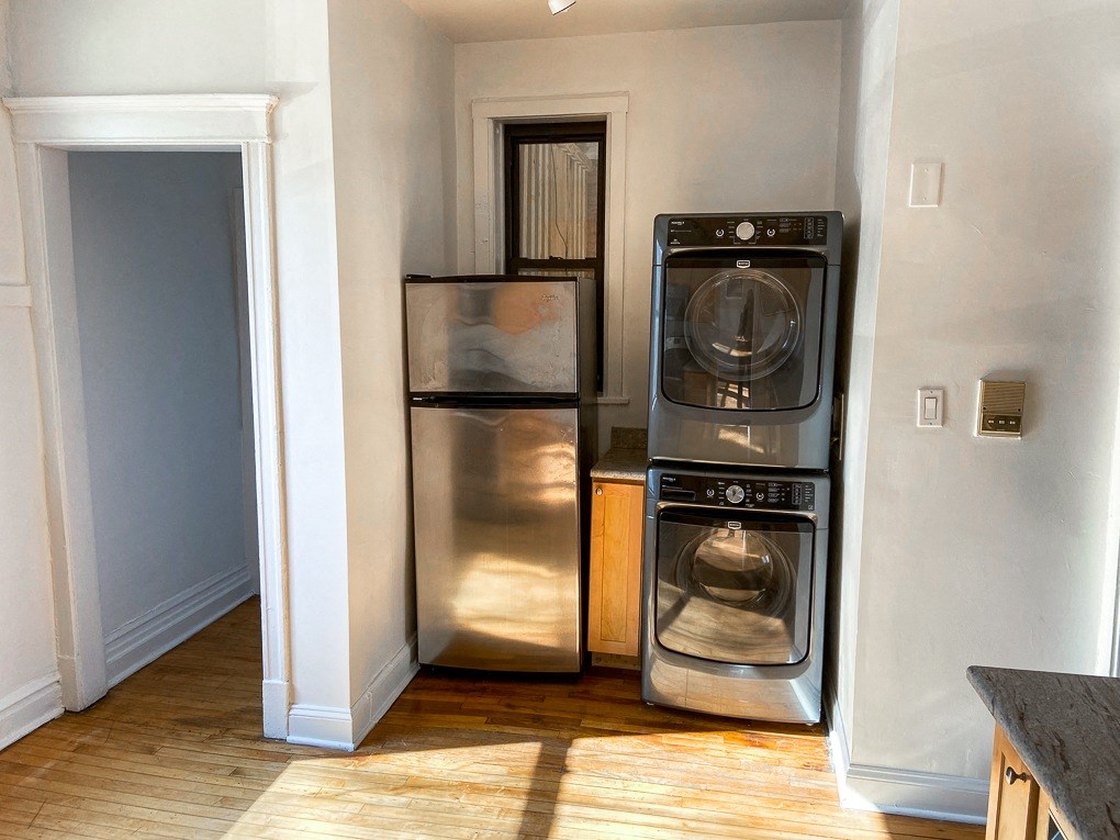 a small laundry room with a washer and dryer and a refrigerator