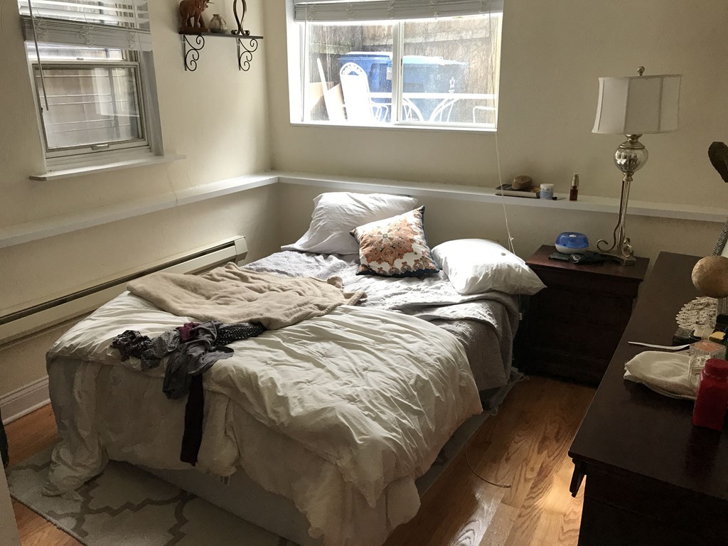 a bedroom with an unmade bed and a window