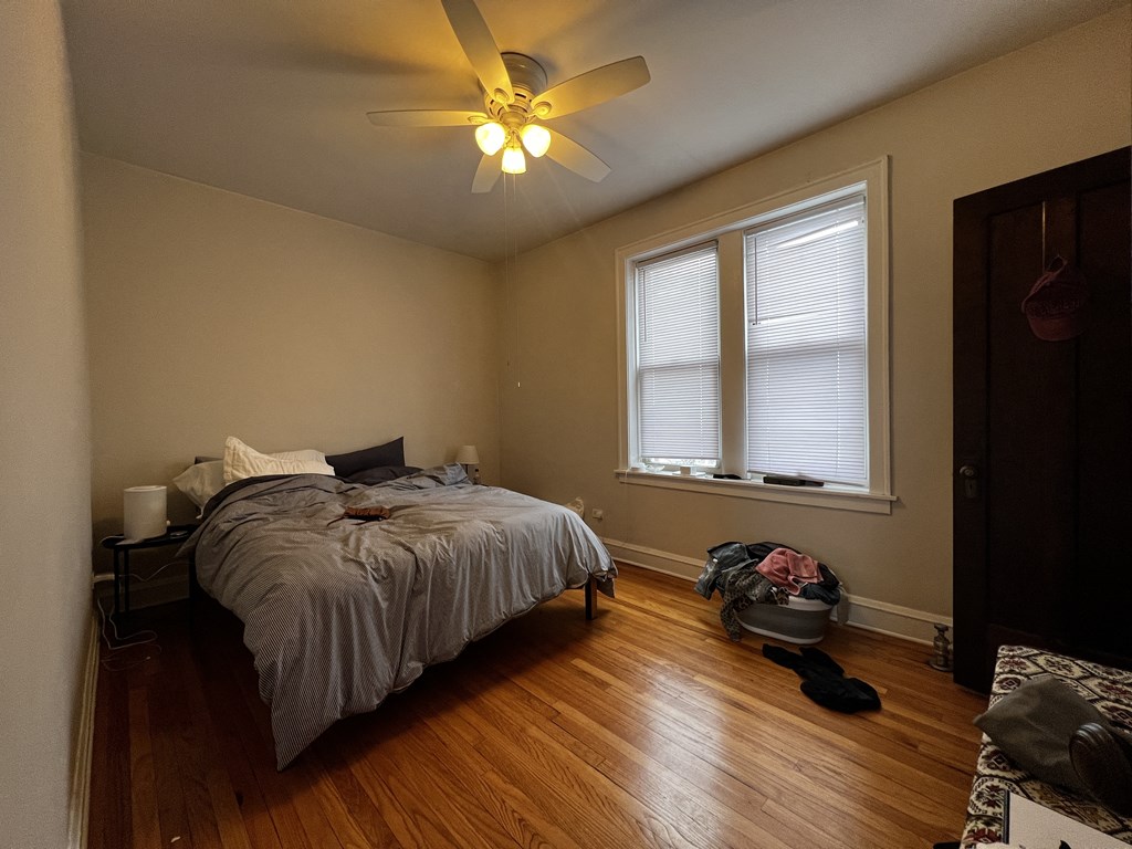 a bedroom with a bed and a ceiling fan