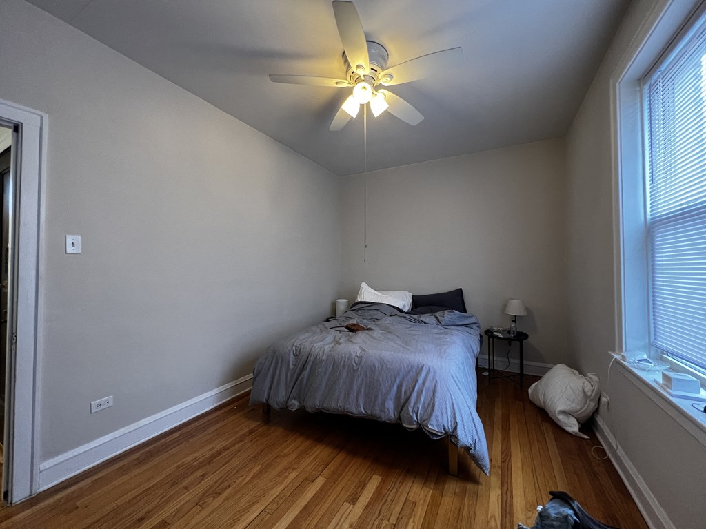 a bedroom with a bed and a ceiling fan