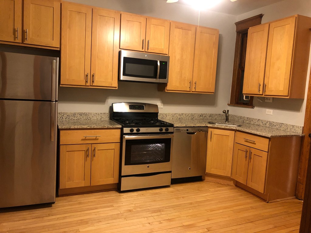 a kitchen with wooden cabinets and stainless steel appliances