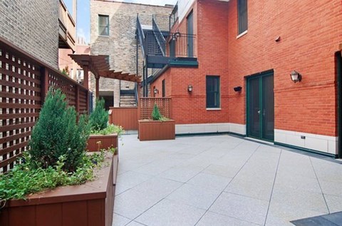A patio with a wooden fence and a planter box.