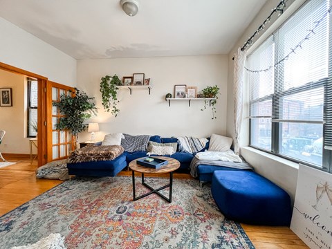 a living room with blue couches and a rug