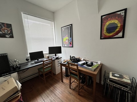 A room with a desk, chair, and computer setup.