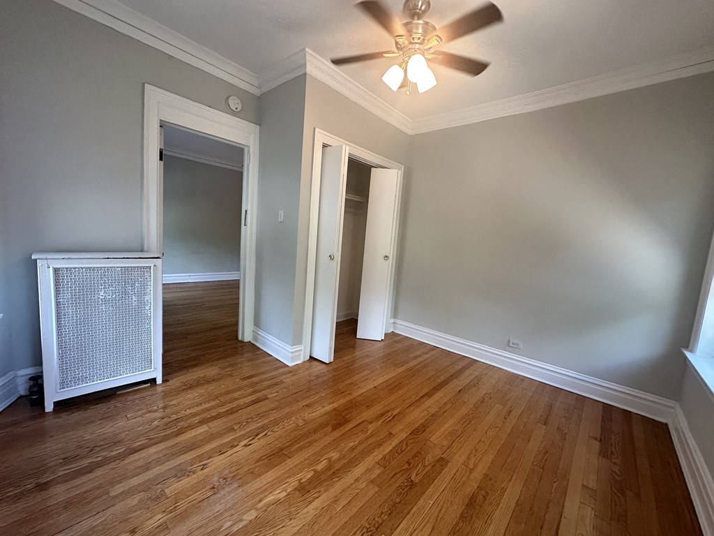 a living room with wood floors and a ceiling fan