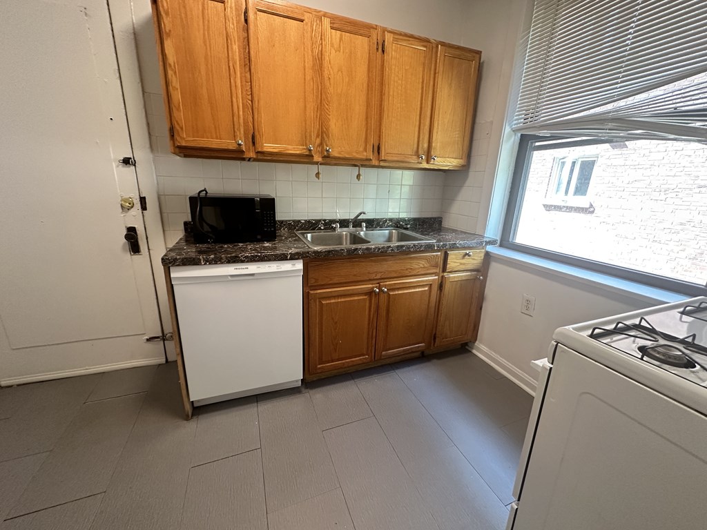 a small kitchen with white appliances and wooden cabinets