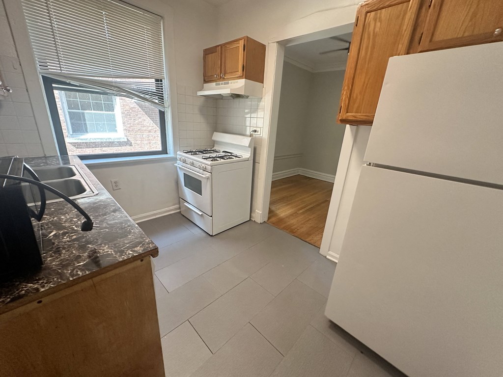 a kitchen with a stove refrigerator and a window