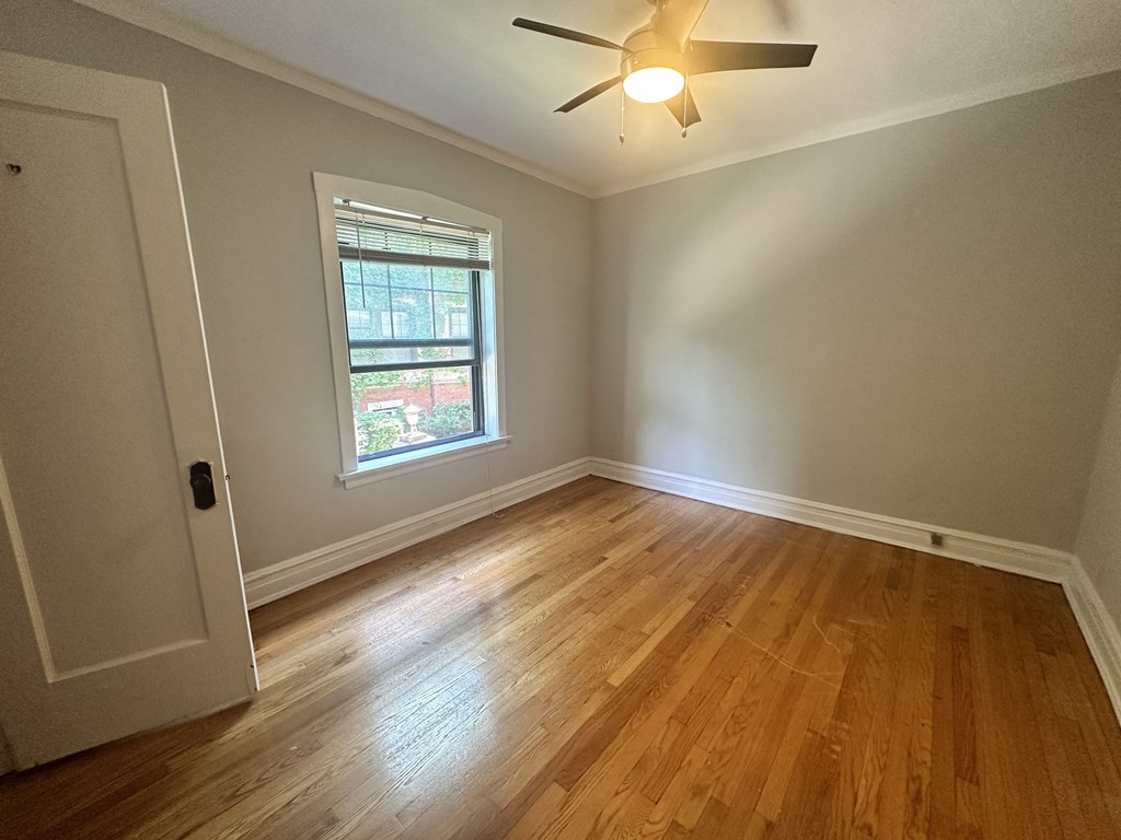 a living room with wood floors and a ceiling fan
