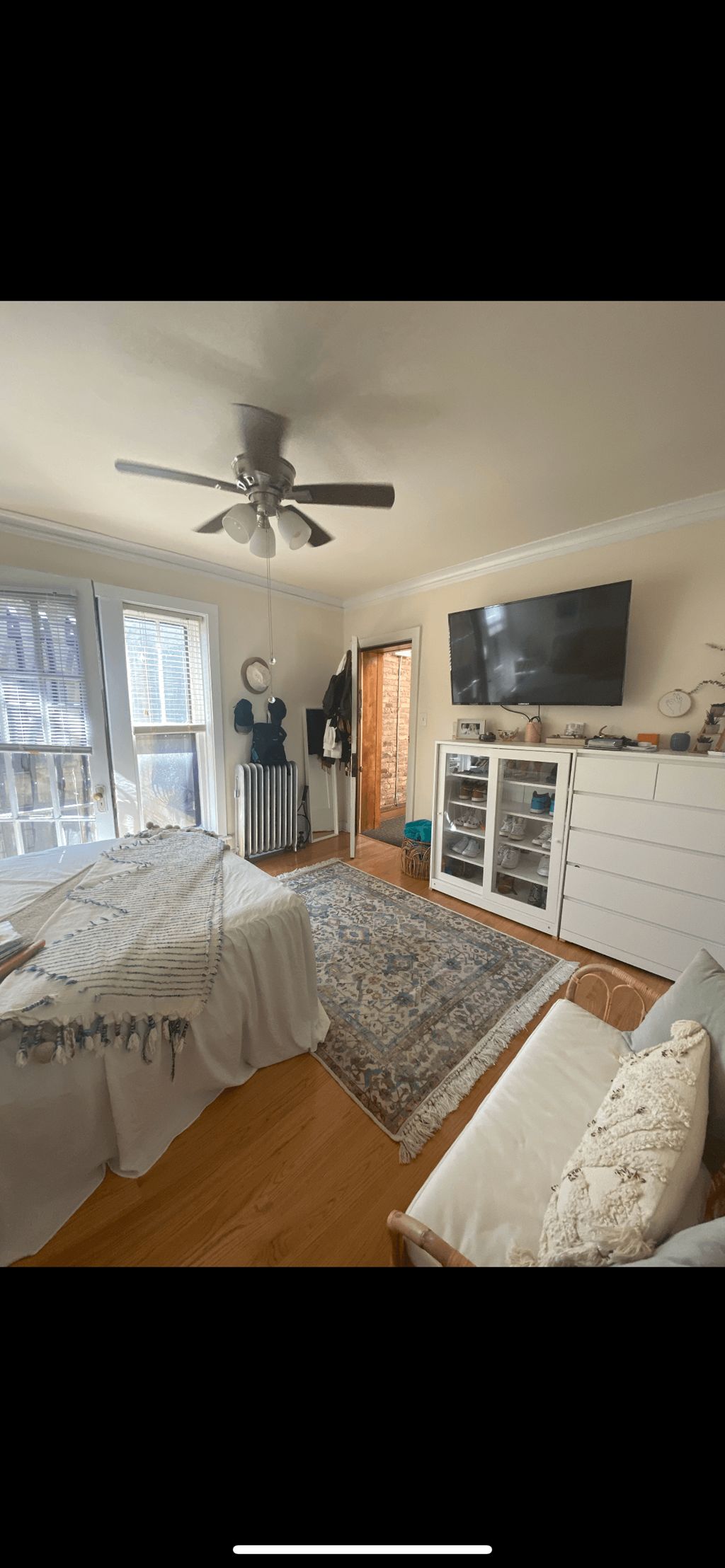 a bedroom with a bed and a ceiling fan and a tv