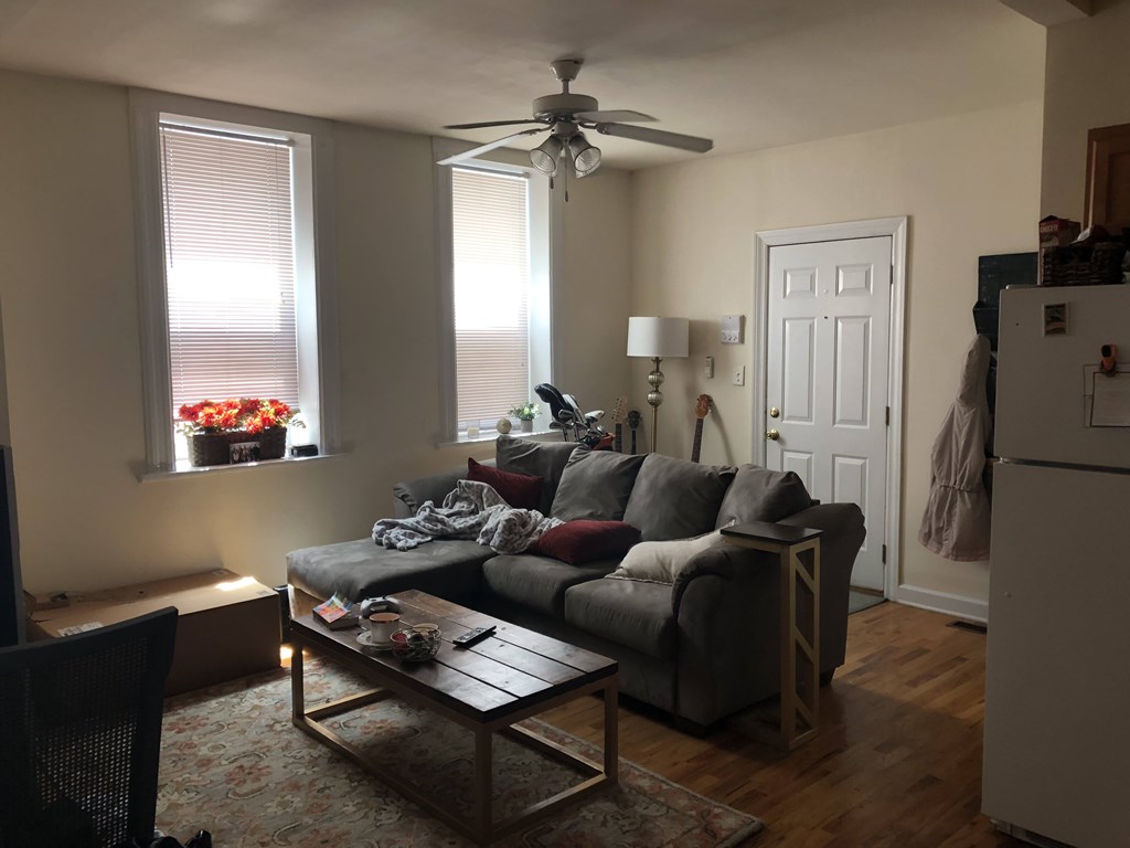 A living room with a grey couch and a wooden coffee table.