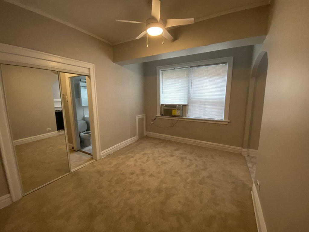 a living room with a ceiling fan and a window