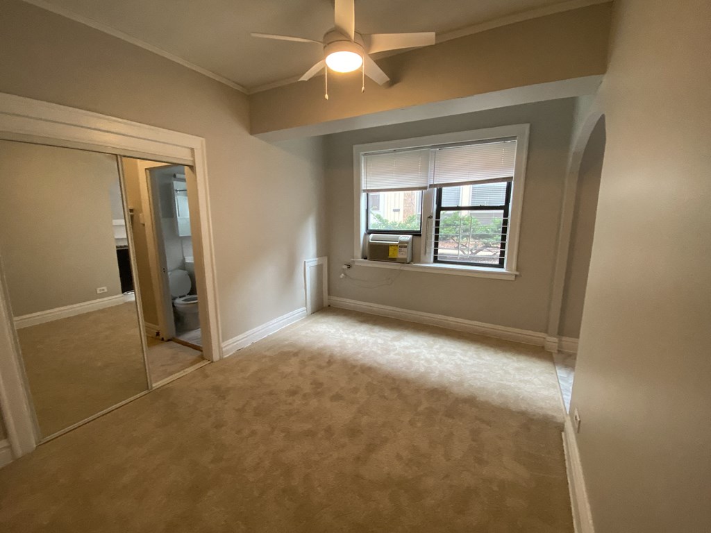 a bedroom with a ceiling fan and a window