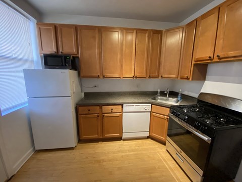 A kitchen with wooden cabinets and a white refrigerator.