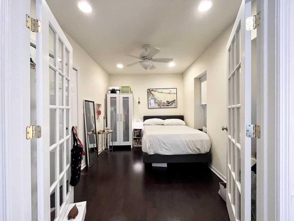 a bedroom with a bed and a ceiling fan