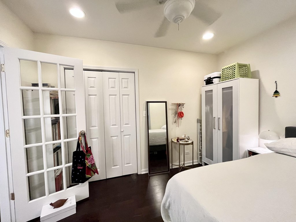 a bedroom with white walls and white closet doors and a white bed