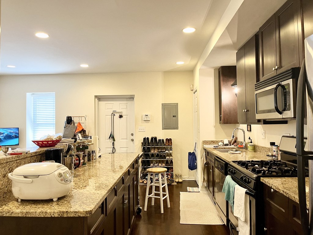a large kitchen with granite counter tops and stainless steel appliances