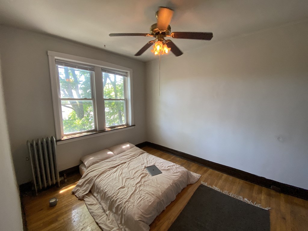 a bedroom with a bed and a ceiling fan