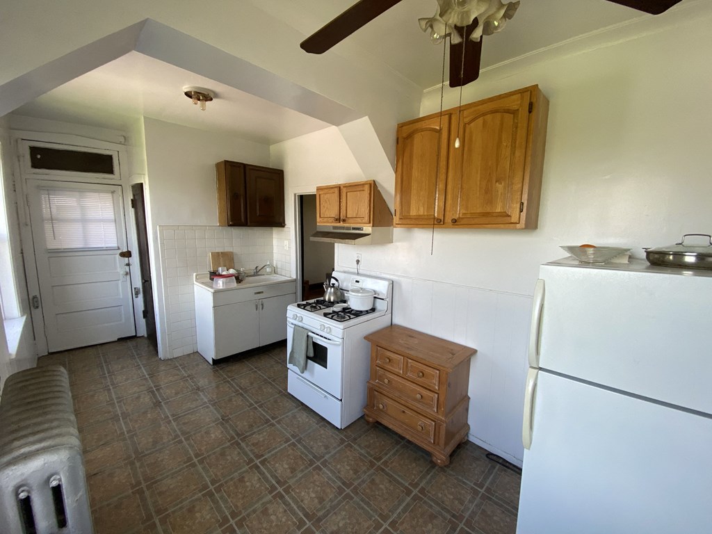 a kitchen with a white stove and a refrigerator